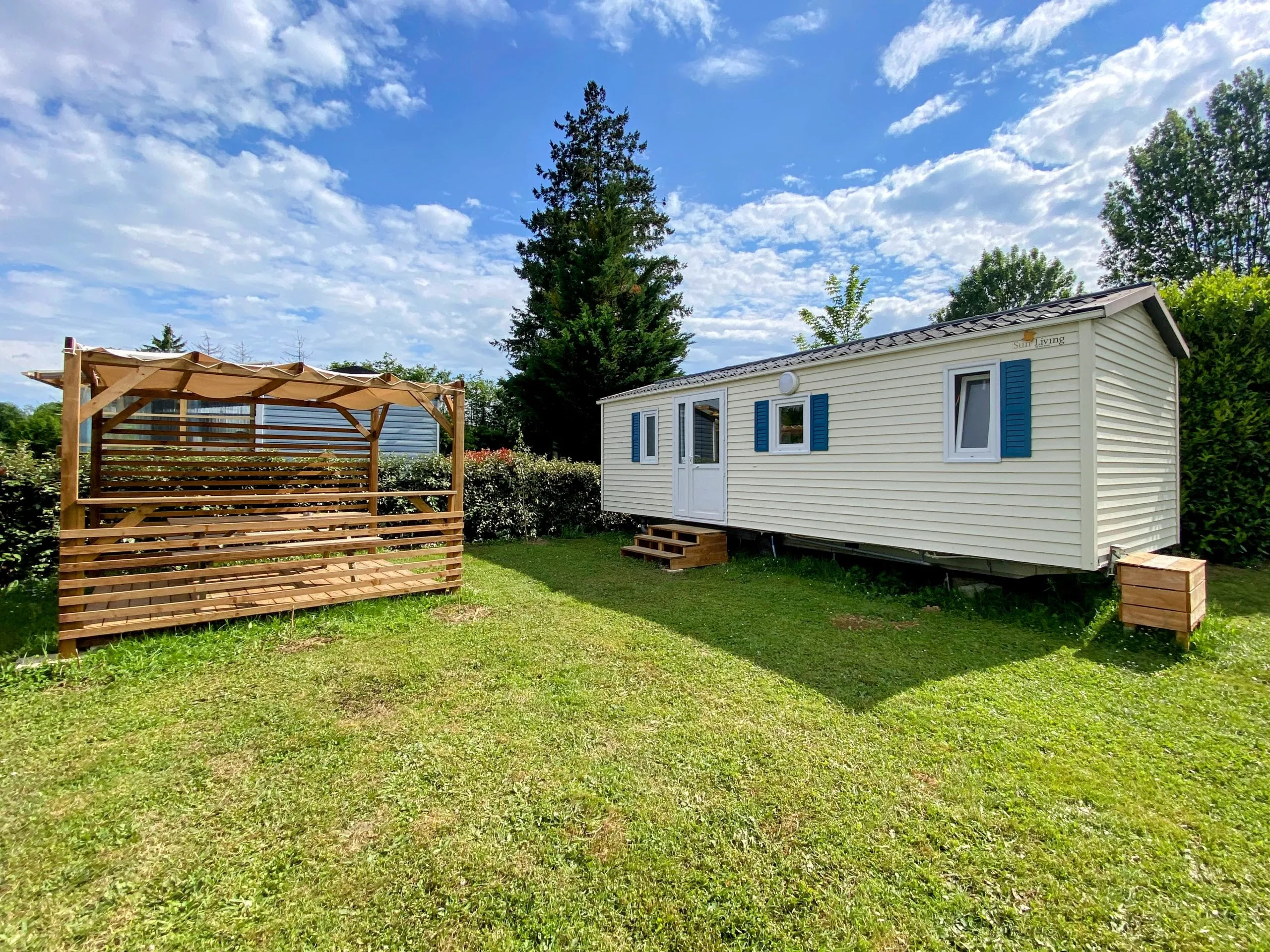 Mobil-home avec terrasse sur un emplacement spacieux délimité par des haies au camping les avenières
