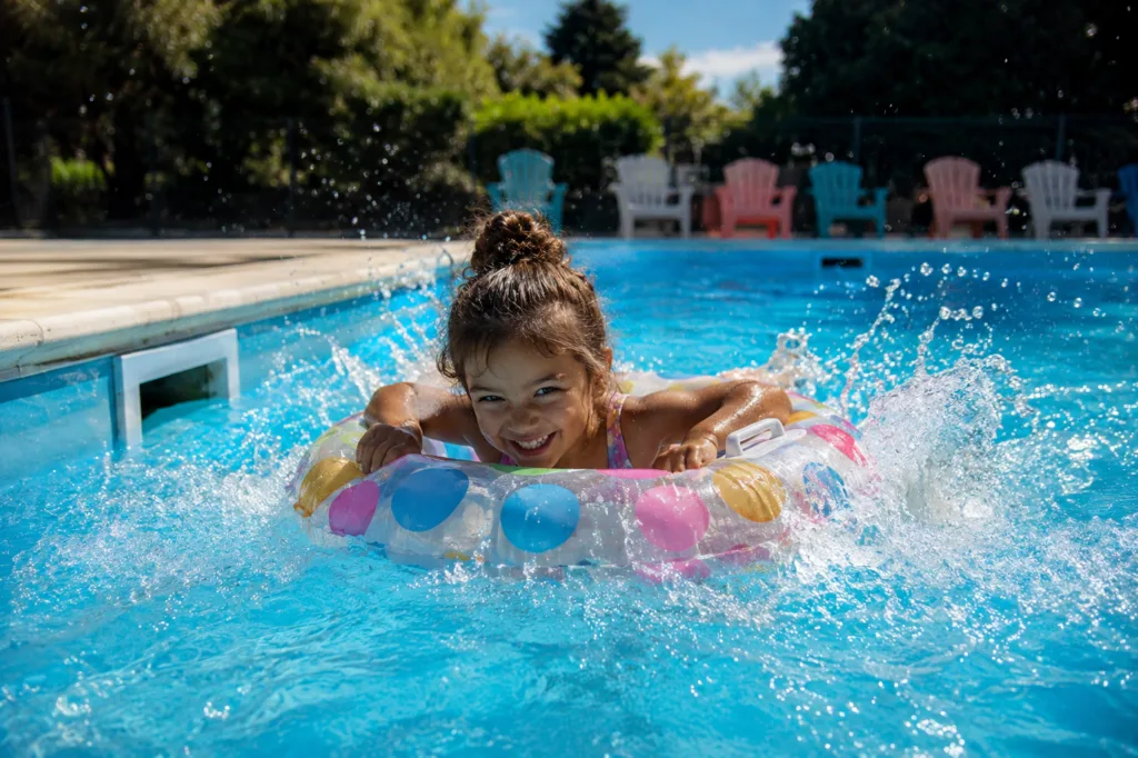 Filette qui joue dans la piscine chauffée du camping les Avenières